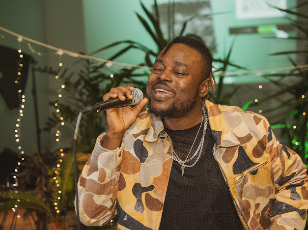 Soul Kitchen vocalist singing into a microphone on stage